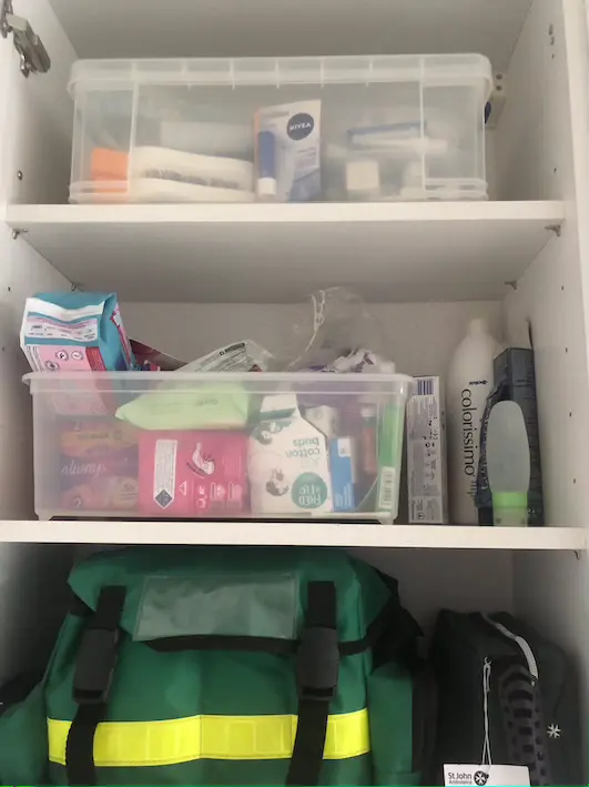 White kitchen cupboard with two shelves full of appliances and miscellaneous kitchen items