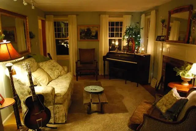 Cosy living room, with upholstered furniture with low level lighting provided by lamps