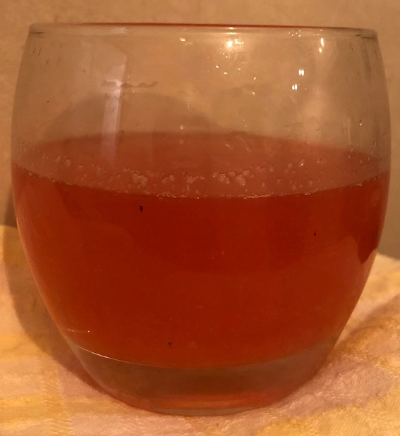 Glass tumbler containing red liquid