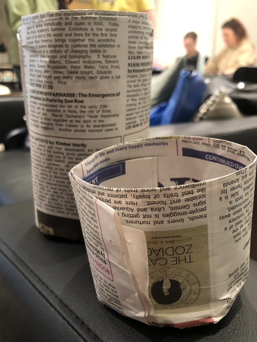 two different sized pots made out of newspaper