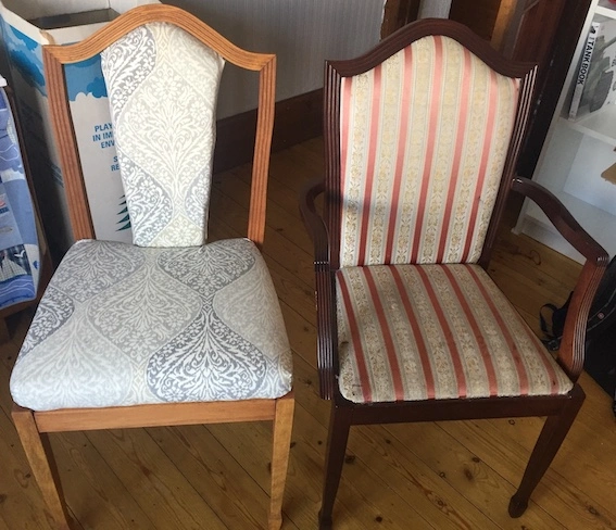 two dining room chairs. One oak coloured wood and grey upholstery. One mahogany wood, with red and cream striped upholstery