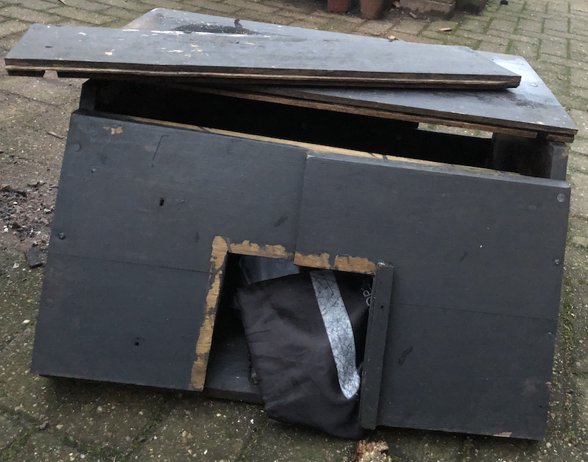 low wooden cat shelter with a damaged roof