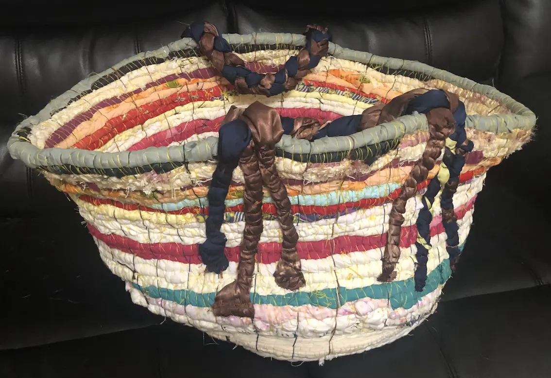 laundry basket formed from rows of rolled, multicoloured fabric sewn together