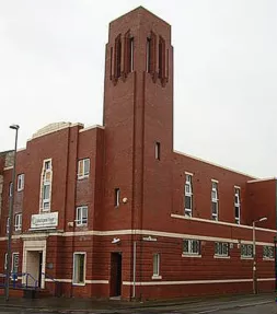 Red brick building with a large square tower on one corner