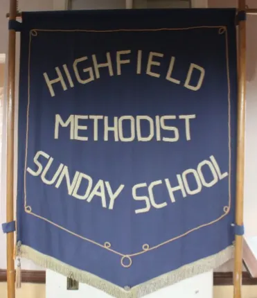 Dark blue banner, a faded yellow fringe, with the words 'Highfield Methodist Sunday School' in faded yellow