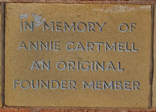 Sandstone memorial stone inscribed 'In memory of Annie Cartmell an original founder member'