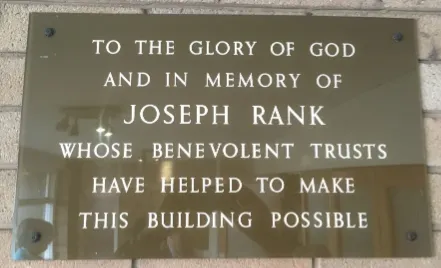 Brown perspex plaque with white lettered inscription to Joseph Rank commemorating the 1967 building of Lindale Methodist Church