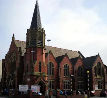 Traditional red brick church with a spire