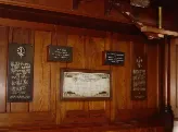 A collection of plaques and a framed roll of honour hanging on a wooden clad wall in Raikes Parade Methodist Church