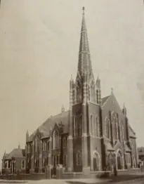 Monochrome image of a traditional red brick church with a spire