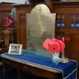 Refurbished First World War brass memorial plaque on a table covered in a blue cloth in Highfield Road Methodist Church