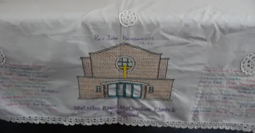 Detail of an embroidered cloth featuring Waterloo Road Methodist Church and numerous names in different colours